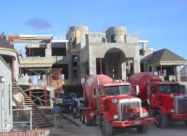A home under construction with two red trucks