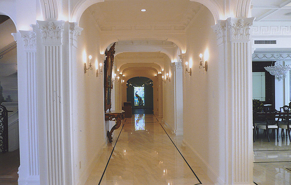 A luxury hallway with crown molding and white walls