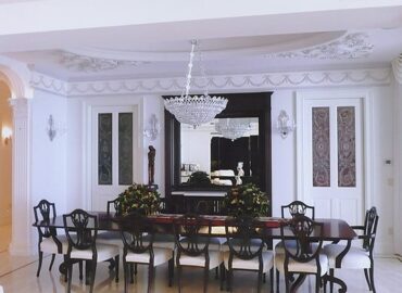 A luxury dining room area with white walls and crown molding