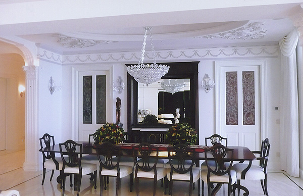 A luxury dining room area with white walls and crown molding