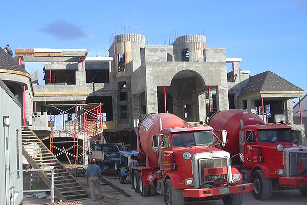 A home under construction with two red trucks
