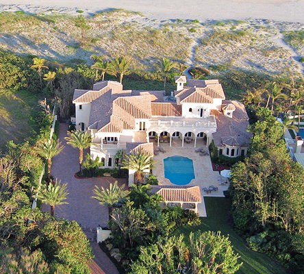 An aerial shot of a beach front home with a pool