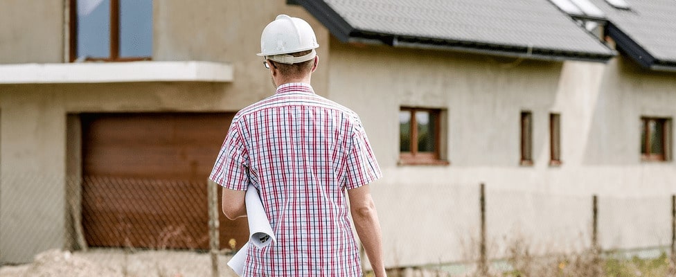 A contractor standing in front of an old home