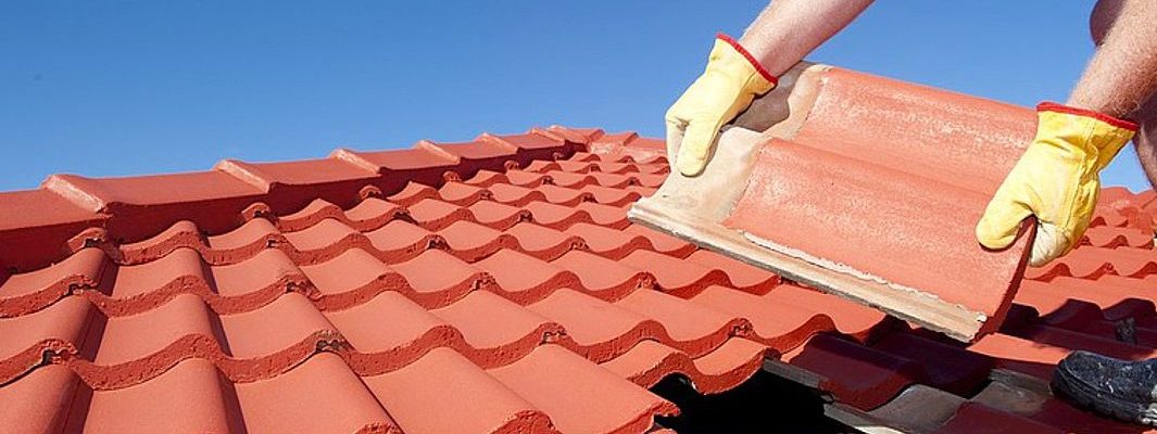 A man installing tile onto a roof