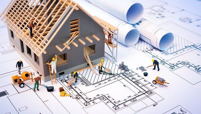 building house on blueprints with worker - construction project