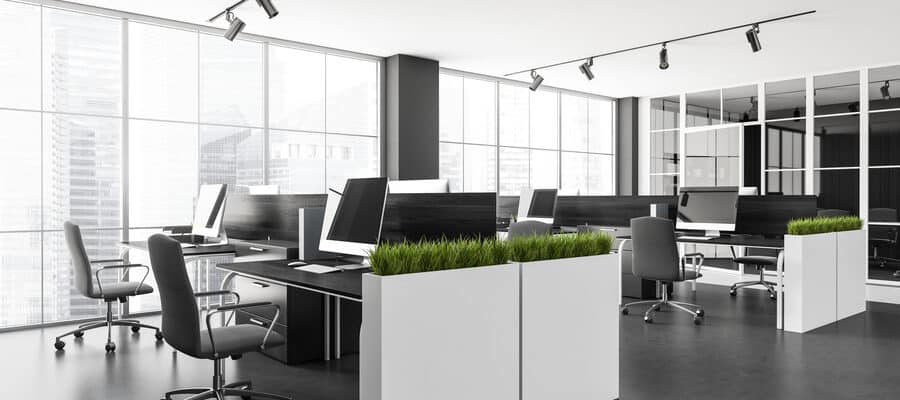 Office room interior with armchairs in row, table with pc computers, dark concrete floor.
